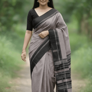Woman in a royal blue Banarasi silk saree with heavy gold zari border standing before a temple.
